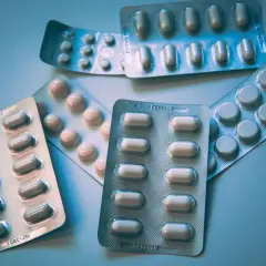 Opakowania tabletek, w tym potencjalny lek na depresję, leżą na jasnym tle.