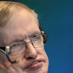 Stephen Hawking, mimo swojej choroby, z okularami i aparaturą do komunikacji, patrzy w dal.