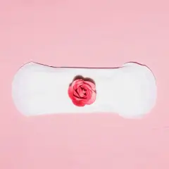 Delikatne krwawienie implantacyjne, symbolizujące nowy początek, na tle różowej tekstury.
