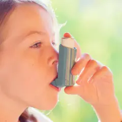 Dziewczynka używa inhalatora Trelegy Ellipta, by swobodnie oddychać.