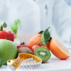 Dietetyk pisze zalecenia dotyczące tego, jak obniżyć potas we krwi, prezentując zdrowe owoce i warzywa.