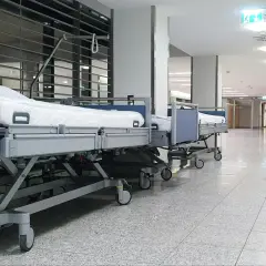 Puste łóżka szpitalne w korytarzu. Zastanawiasz się, ile zarabia salowa w szpitalu?