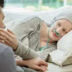 Kobieta z rakiem jajnika, podtrzymywana przez ukochanego, z nadzieją patrzy w przyszłość, mimo trudnych rokowań.