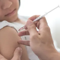 Dziecko otrzymuje szczepienie przeciwko polio. Lekarz podaje zastrzyk, chroniąc przed tą groźną chorobą.