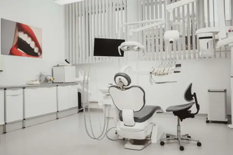 Nowoczesny gabinet stomatologiczny z fotelem dentystycznym, lampą i obrazem ust.
