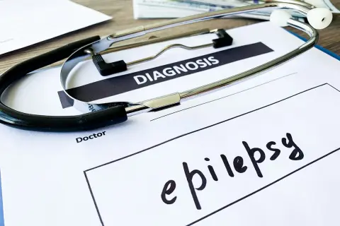 Stetoskop na dokumencie z napisem "DIAGNOSIS" i odręcznie wpisaną diagnozą: epilepsja.