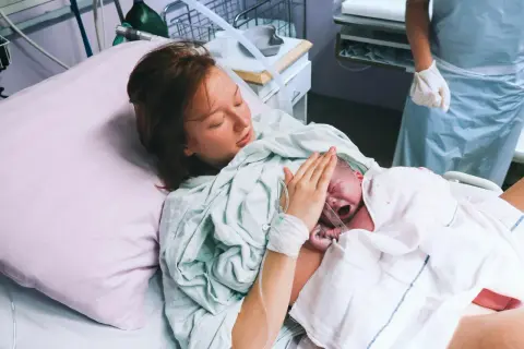 Mama tuli tulostamaan lapsen, joka oli syntynyt kleszczowy. Lapsi itkee, mutta äiti on onnellinen.