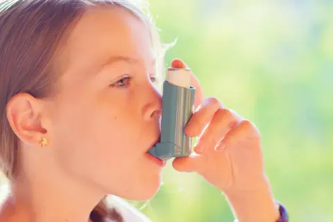 Dziewczynka używa inhalatora Trelegy Ellipta, by swobodnie oddychać.