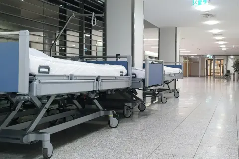 Puste łóżka szpitalne w korytarzu. Zastanawiasz się, ile zarabia salowa w szpitalu?