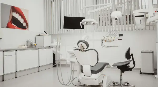 Nowoczesny gabinet stomatologiczny z fotelem dentystycznym, lampą i obrazem ust.