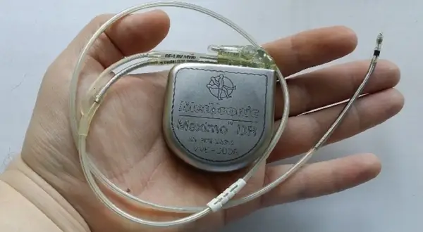 Kardiowerter Medtronic Maximo DR z elektrodami w dłoni.