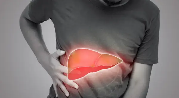 Mężczyzna trzyma się za brzuch, gdzie widoczna jest podświetlona, czerwona wątroba. Może to symbolizować zapalenie wątroby typu c objawy.