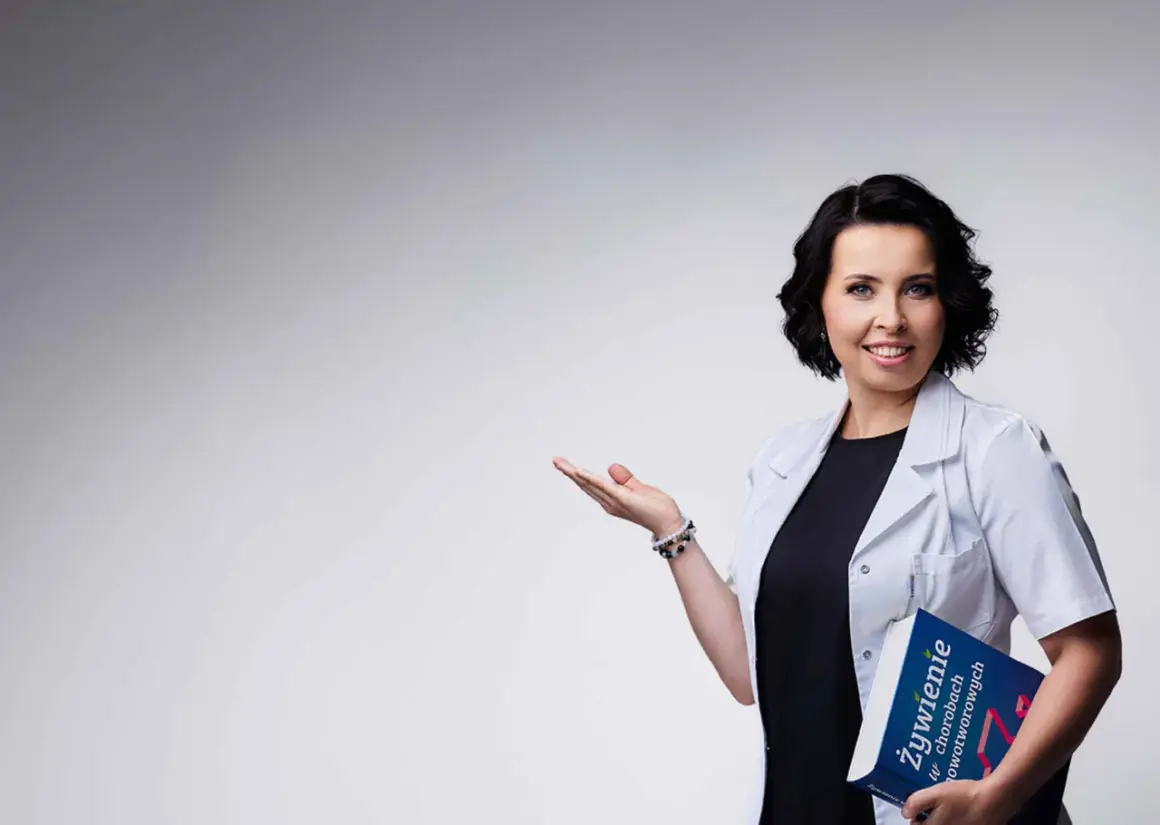 Dietetyczka kliniczna z książką o żywieniu w chorobach nowotworowych, gestem zaprasza do rozmowy.