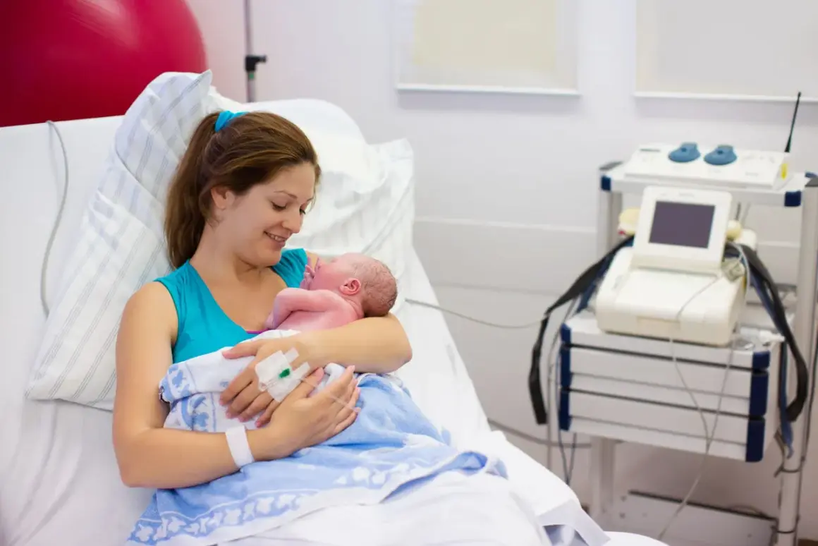 Szczęśliwa mama tuli noworodka po cesarce francuskiej. W tle sprzęt medyczny.