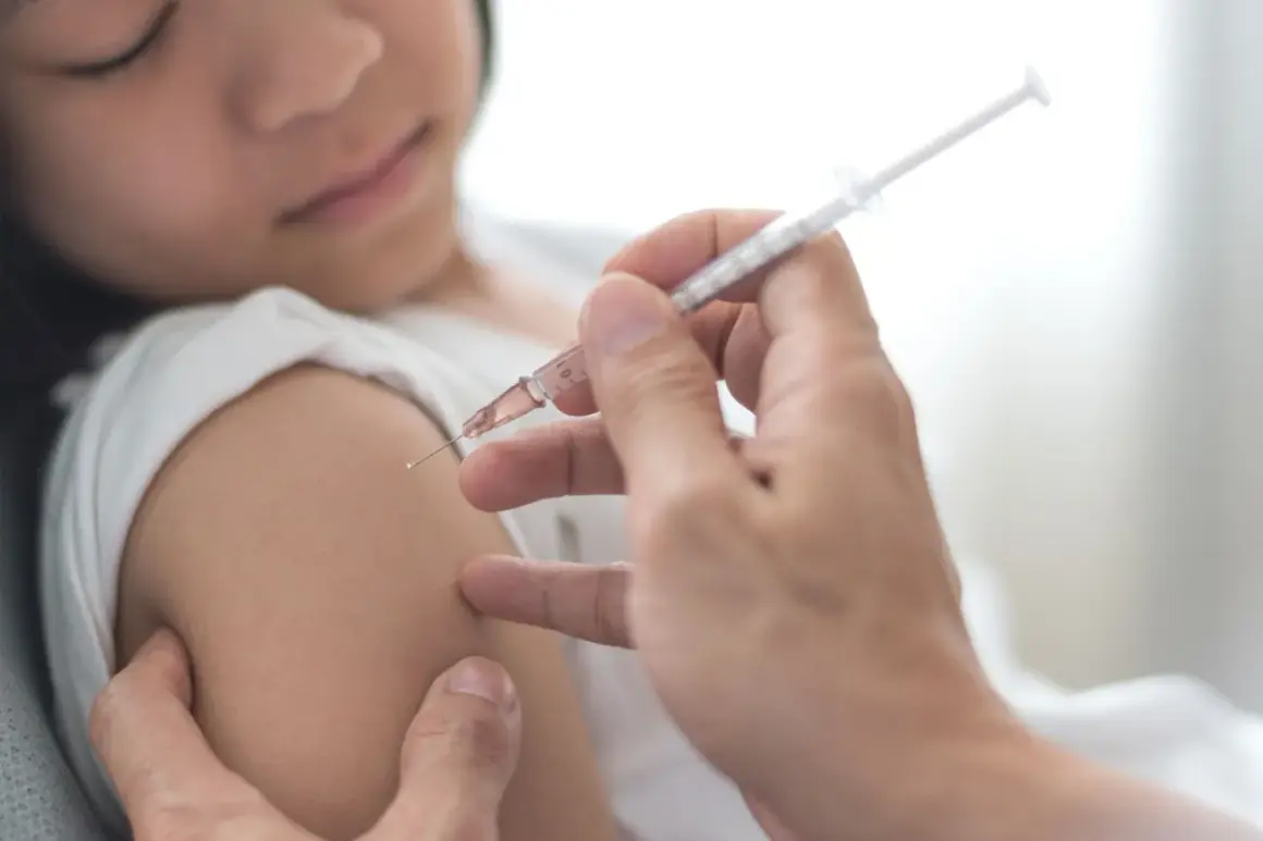 Dziecko otrzymuje szczepienie przeciwko polio. Lekarz podaje zastrzyk, chroniąc przed tą groźną chorobą.