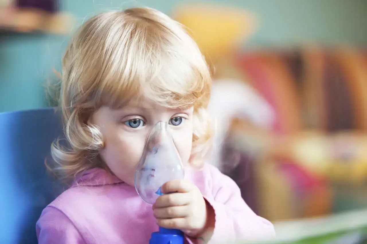 Mała dziewczynka z niebieskimi oczami wdycha lek przez nebulizator. Czy to klątwa Ondyny, która sprawia, że musi walczyć o każdy oddech?