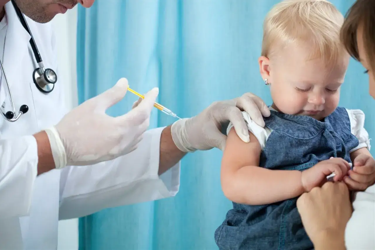 Lekarz podaje szczepionkę dziecku, chroniąc je przed chorobą polio.