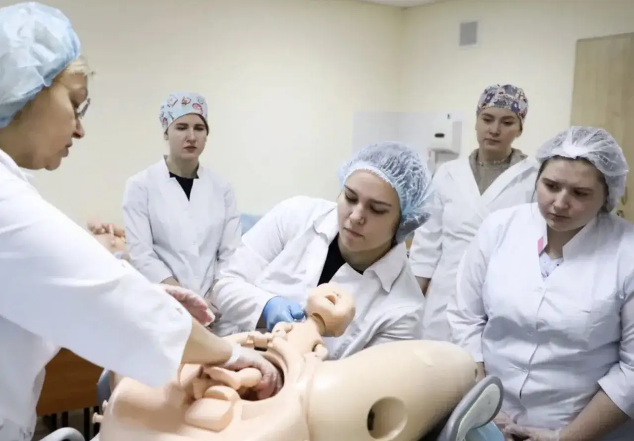 Studentki ćwiczą poród na fantomie, ucząc się m.in. chwytu Kristellera.