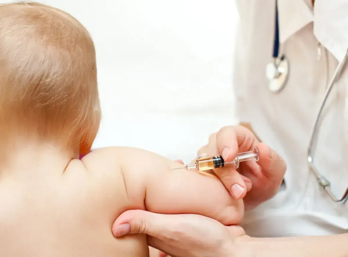 Dziecko otrzymuje szczepienie przeciwko polio. Lekarz podaje zastrzyk, chroniąc malucha przed tą groźną chorobą.